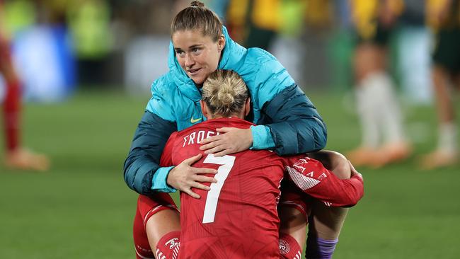 Reserve goalkeeper Teagan Micah embraces Sanne Troelsgaard of Denmark.