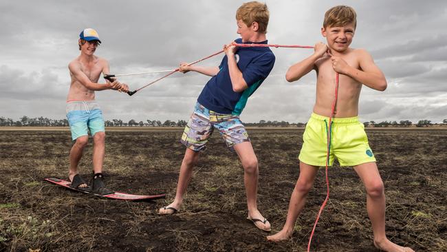 Damon Grigg, 9, Aaron Towbridge, 15, and Hayden Trowbridge, 15, stand on a jetty at a completely dry Lake Wallace in Edenhope in Western Victoria. Picture: Jake Nowakowski