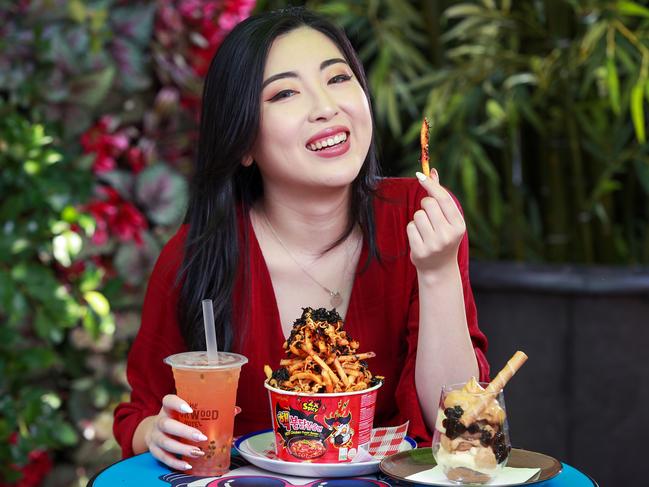 Shirley Li with Burwood Hotel's Insta faves Nuclear Fire Noodle Fries, a Tropical Boba Tea cocktail and Dalgona Bobamisu. Picture: Justin Lloyd