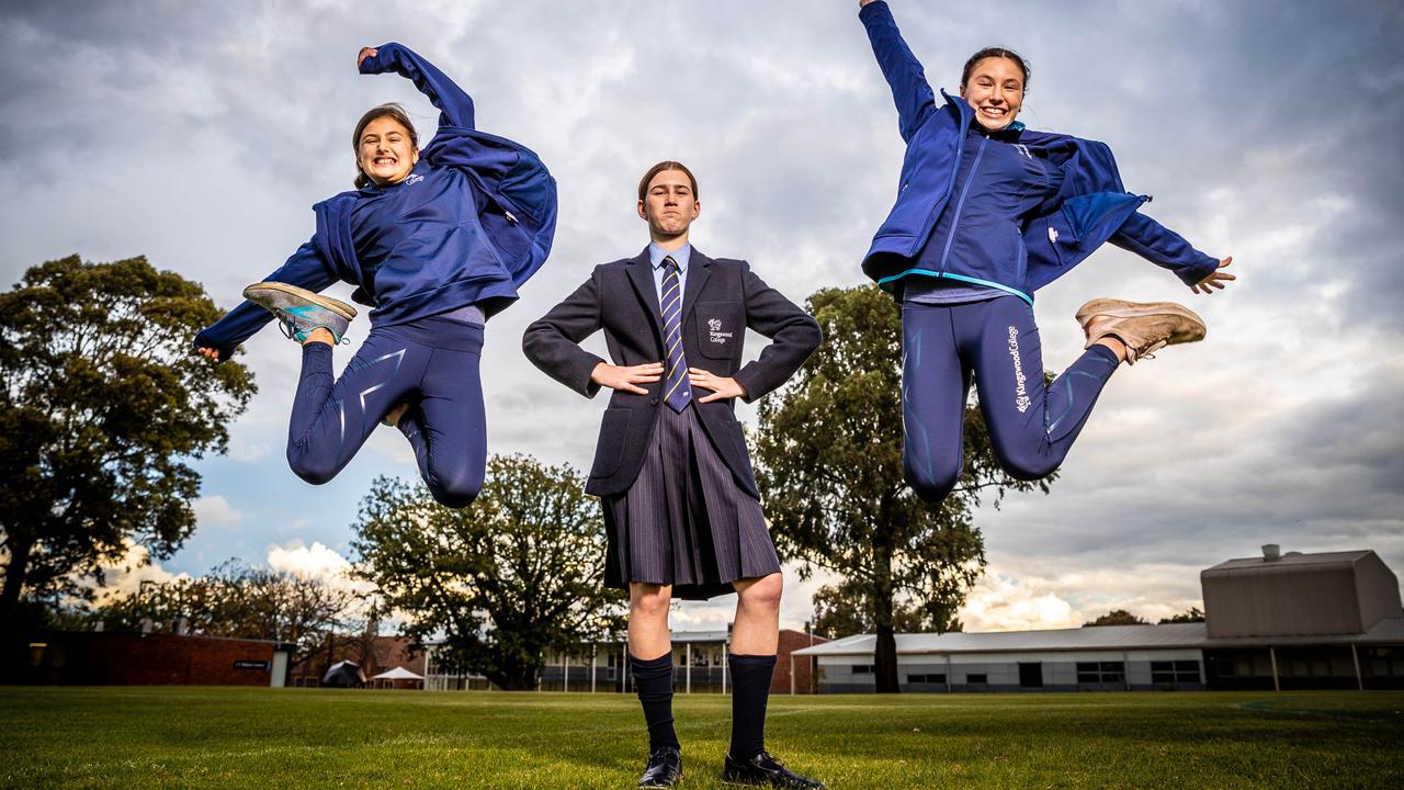 Kingswood College has switched to a permanent sports uniform. Charlotte, 11, left and Issey, 13, right, jump for joy in their new outfits while Lucy, 13, centre, wears the old uniform. Picture: Jake Nowakowski
