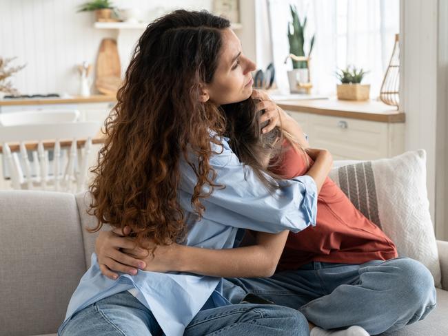 Caring loving mother comforting hugging unhappy sad teenage daughter, sitting together on sofa at home, mom supporting depressed teen girl child, parent making peace with kid. Parenting of adolescentsmum hug teenager daughter   istock image