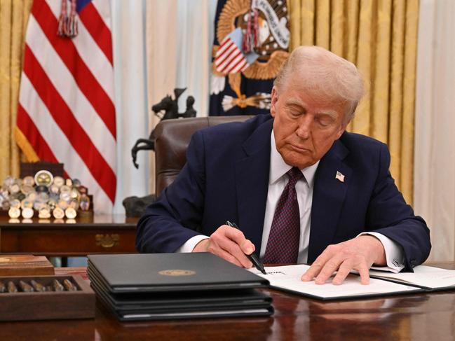 US President Donald Trump signs an executive order to declassify files of former President John F. Kennedy, former Attorney General Robert F. Kennedy and civil rights leader Martin Luther King Jr., in the Oval Office of the White House in Washington, DC, on January 23, 2025. (Photo by ROBERTO SCHMIDT / AFP)