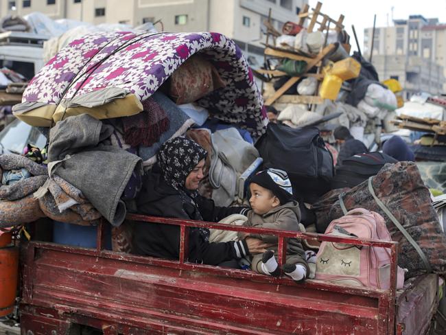 Displaced Palestinians gather with their belongings near a roadblock on Salah al-Din Street, as they wait to return to their homes in the northern part of the Gaza Strip, Sunday, Jan. 26, 2025, days after the ceasefire deal between Israel and Hamas came into effect. (AP Photo/Jehad Alshrafi)