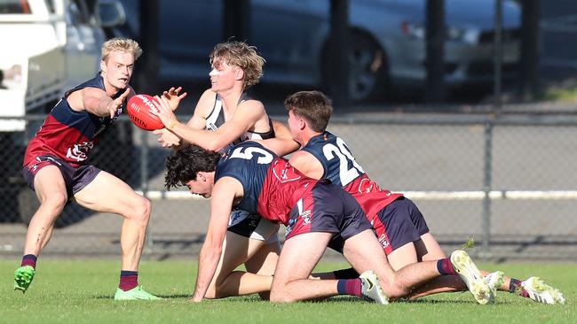 Sandhurst’s Lachlan Tardrew, Tom Campbell and Oliver Morris outnumber a Castlemaine opponent.