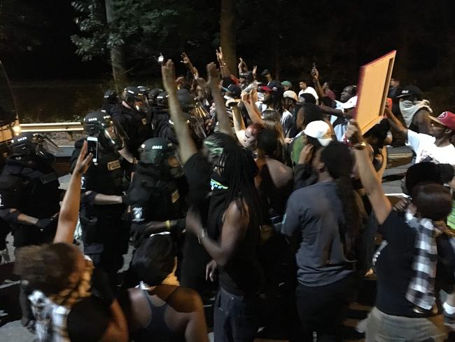 Police gathered around protesters following the fatal police shooting of a black man, with a dozen officers and several demonstrators injured in the violence. Picture: AFP
