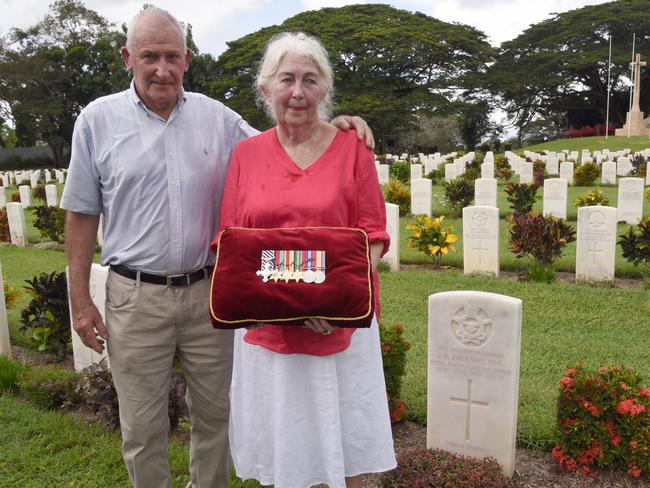 Arthur and Patricia Jackson, the son and daughter of 75 Squadron hero John Jackson, at his grave in Bomana War Cemetery, PNG. Picture: Supplied