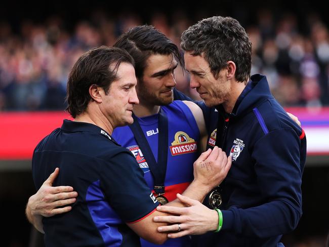 Western Bulldogs coach Luke Beveridge, captain Easton Wood and Murphy hug on stage after Beveridge gave Murphy his premiership medal, in one of the great footy moments. Picture. Phil Hillyard