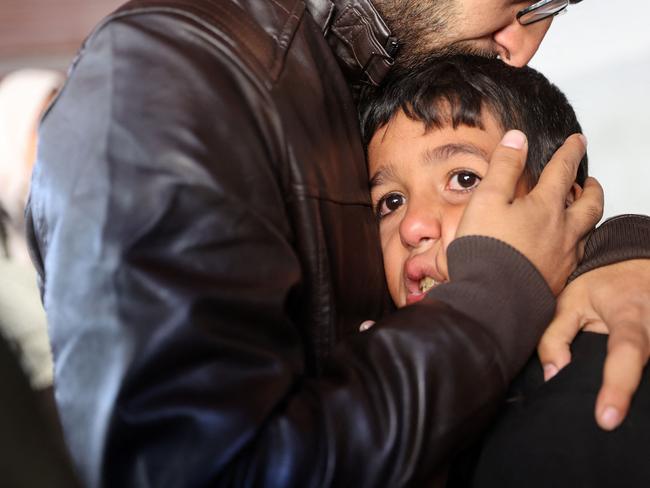 A man comforts a child as people mourn the death of members of the Palestinian Akasha family on Saturday. The family were killed in an Israeli strike on the Sheikh Adwan neighbourhood north of Gaza City. Picture: AFP