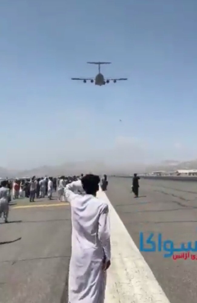 A person appears to fall from a US air force plane as it takes off from Kabul Airport.