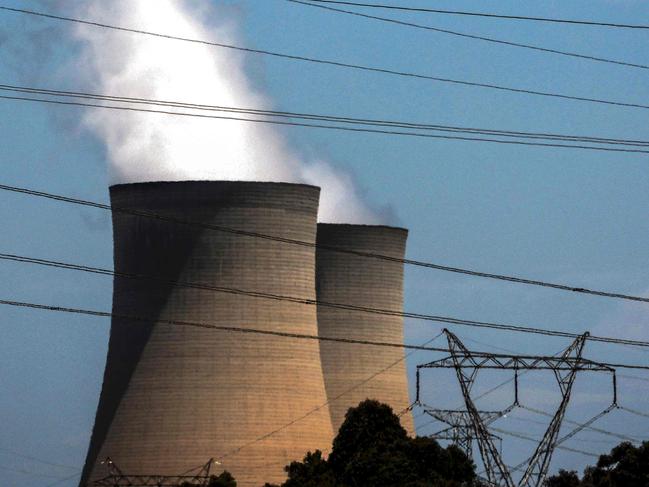 (FILES) This photo taken on December 13, 2023 shows electricity lines passing near the emission funnels of the Bayswater coal-powered thermal power station near the central New South Wales town of Muswellbrook. Australia's reliance on coal-fired power stations has dropped to a record low, providing less than 50 percent of its electricity for the first time, the market operator said on January 30, 2025. (Photo by DAVID GRAY / AFP)