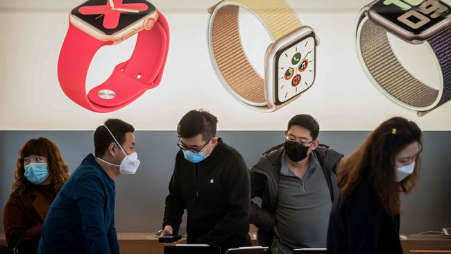 Staff and customers in an Apple store in Beijing. Picture: AFP