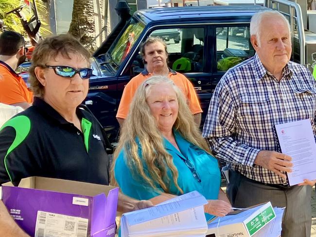 Donna Layton (centre in blue) handing over the submissions to Mayor Ian Tiley (far right).