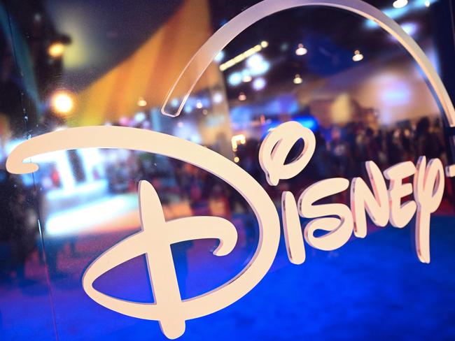 (FILES) In this file photo taken on September 09, 2022 fans are reflected in Disney+ logo during the Walt Disney D23 Expo in Anaheim, California. - Disney's streaming service saw its first ever fall in subscribers last quarter, company data showed on February 8, 2023, as consumers cut back on spending amid higher costs and a souring global economy. Disney CEO Bob Iger on February 8, 2023, announced that the company would lay off 7,000 workers, in the veteran executive's first major decision since returning to lead the company in November. (Photo by Patrick T. FALLON / AFP)