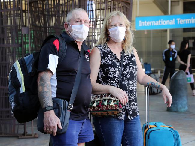 Masked travellers: Michael Mitchell and Michelle Mitchell pictured at Sydney International Airport. Masks are set to be the norm for flights for the foreseeable future. Picture: Richard Dobson