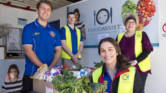 ( From left ) Assistant coach Matt Cox, Jordan Biggar, Tracey Twidale with Annette Rose, general manager Actscare. Toowoomba Mountaineers players help out at Foodassist. Friday, 1st May, 2020.