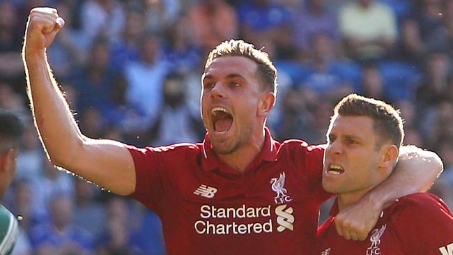 Liverpool's English midfielder James Milner (R) celebrates scoring their second goal from the penalty spot with Liverpool's English midfielder Jordan Henderson (C) during the English Premier League football match between between Cardiff City and Liverpool at Cardiff City Stadium in Cardiff, south Wales on April 21, 2019. (Photo by GEOFF CADDICK / AFP) / RESTRICTED TO EDITORIAL USE. No use with unauthorized audio, video, data, fixture lists, club/league logos or 'live' services. Online in-match use limited to 120 images. An additional 40 images may be used in extra time. No video emulation. Social media in-match use limited to 120 images. An additional 40 images may be used in extra time. No use in betting publications, games or single club/league/player publications. /