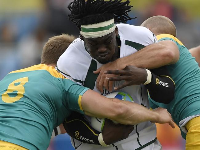 TOPSHOT - South Africa's Tim Agaba (C) is tackled by Australia's Pat Mccutcheon (L) and Australia's James Stannard in the men’s rugby sevens match between South Africa and Australia during the Rio 2016 Olympic Games at Deodoro Stadium in Rio de Janeiro on August 10, 2016. / AFP PHOTO / PHILIPPE LOPEZ