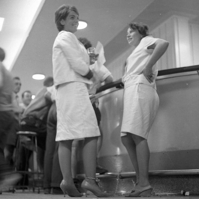 31/3/1965 Chained to the footrail in the public bar of the Regatta Hotel, Toowong, are Mrs Rosalie Bogner, left, of Indooroopilly, and Merle Thornton of Fig Tree Pocket. The pair relaxed with a glass of beer bought for them by a hotel patron. They were drawing attention to their campaign to give women the right to drink side-by-side with men in public bars. Picture by Bruce Postle RA212-2 pub 1/4/65 The Courier-Mail Photo Archive.