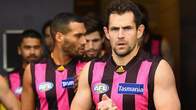Luke Hodge of the Hawks leads his team out onto the field.