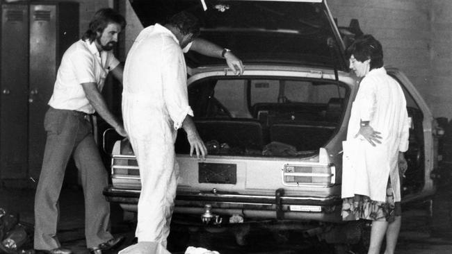 Forensic scientists inspect the Chamberlain car at police headquarters.