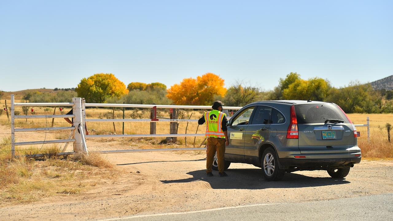 A security guard speaks to a person from the Office of the Medical Investigator at the entrance to the Bonanza Creek Ranch. Picture: Getty