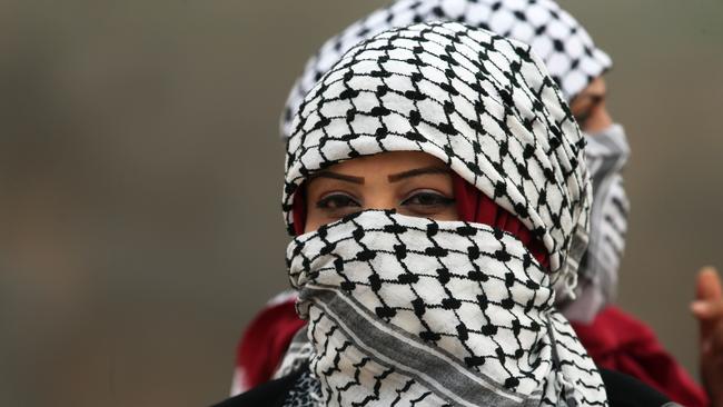 Palestinian women with their faces covered in traditional Palestinian keffiyeh scarves. Picture: AFP