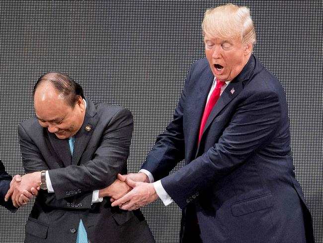 US President Donald Trump struggles to come to grips with the handshake with Vietnam's Prime Minister Nguyen Xuan Phuc. Picture: AFP