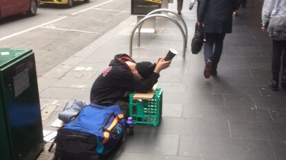 A man begs near the corner of Elizabeth and Flinders streets.