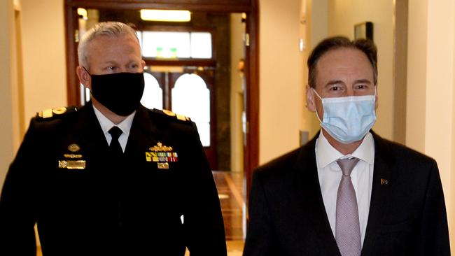 Commodore Eric Young of the Vaccine Operations Centre and Health Minister Greg Hunt in Melbourne on Monday. Picture: Andrew Henshaw