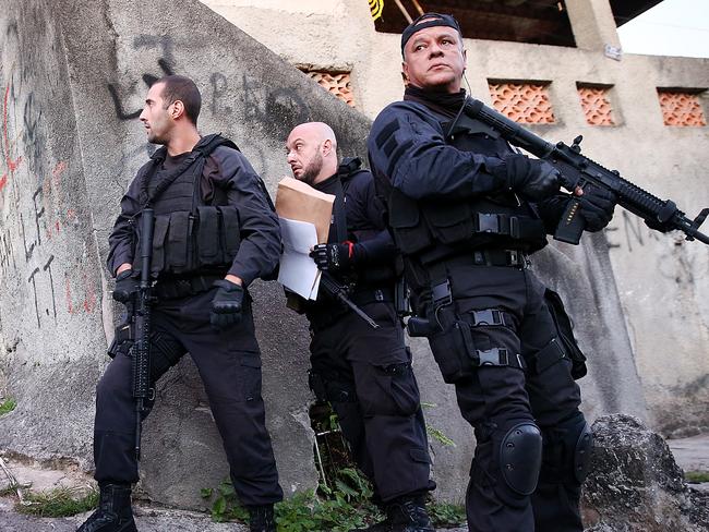 Officers from the CORE police special forces hold their weapons during an operation to search for fugitives in Rio de Janeiro this week.