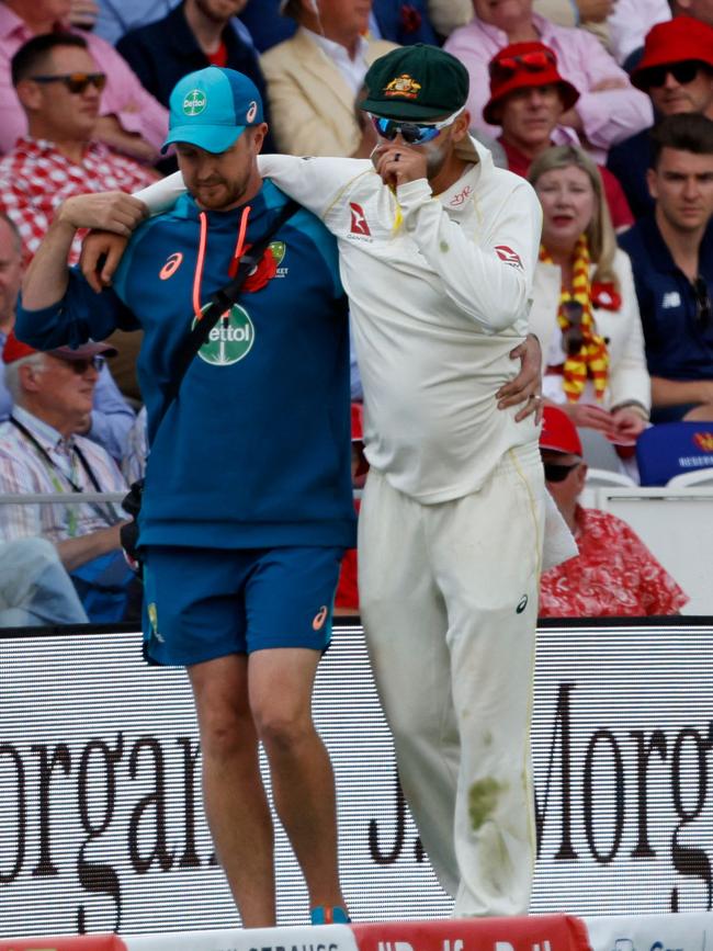 Nathan Lyon appears upset as he is helped around the boundary. Picture: Ian Kington / AFP
