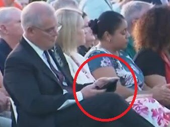 Scott Morrison on his phone during an Anzac Day service.