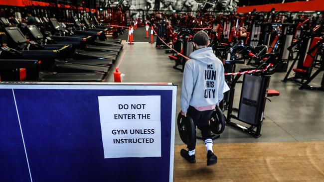 A man carries weights onto the gym floor at the Muscle City gym in Mount Waverley. Picture: Asanka Ratnayake/Getty Images