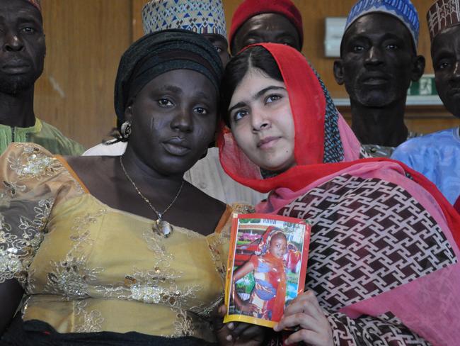 Yousafzai holds a picture of kidnapped schoolgirl Sarah Samuel with her mother Rebecca during a visit to Abuja, Nigeria. Picture: Olamikan Gbemiga