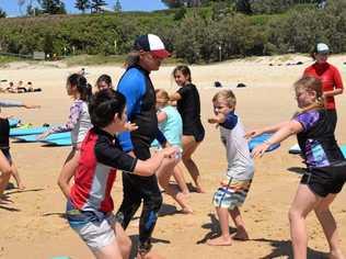 OCEANS OF FUN: Dean Marshall and Rainbow Beach Learn to Surf owner Sarah Booth gave lessons to the visitors. Picture: Arthur Gorrie