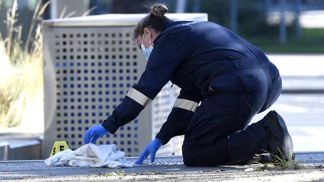 A forensic officer investigates evidence from the Docklands crime scene. Picture: Andrew Henshaw