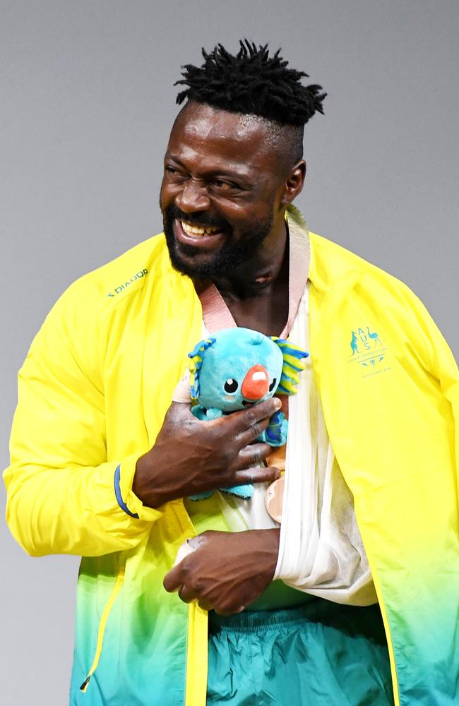 Francois Etoundi of Australia winces in pain after an official patted him on his injured shoulder as he wins bronze in the Men's 77kg final on day three of the XXI Commonwealth Games. Picture: AAP Image/Tracey Nearmy