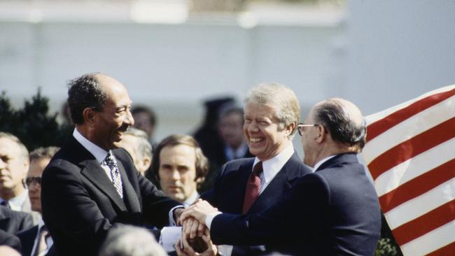 Egyptian president Anwar Sadat, president Jimmy Carter, centre, and Israeli prime minister Menachem Begin after the signing the Camp David Accords in 1979. Picture: Getty Images