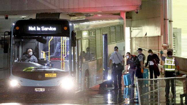 Travellers were led onto a bus at the international terminal Sydney Airport, to be taken to a hotel for quarantine. Picture: Damian Shaw