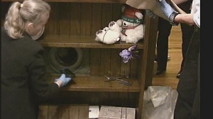 The gun used in the murder is removed by police from Judy’s safe.