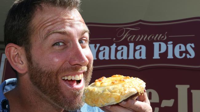 Journalist Ryan Keen trying out the special edition Cyclone Debbie pie, which featured a ring of cheesy pineapple on top. We think he liked it. Picture: Glenn Hampson