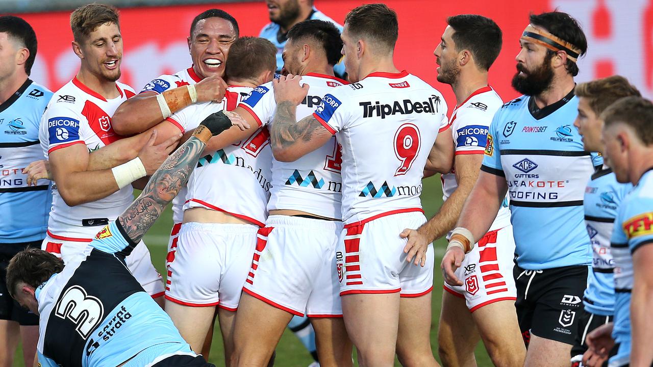 Matt Dufty of the Dragons celebrates with teammates after scoring a try.