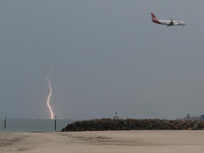 A plane comes into land at Adelaide Airport with lightning in the background from a storm on its way to Adelaide. Photograph taken from Glenelg at 7:00PM. Storm on its way. 03/11/15  Picture: Stephen Laffer