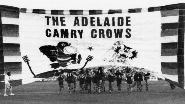 The Crows players run through the team banner and on to the field for their first competitive match in the first round of the Foster's Cup against Geelong on February 13, 1991. 