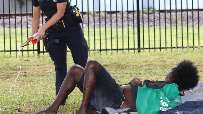 Cairns Police Constable Chonea Davey speaks to a man in the Pioneer Cemetery and tips out his alcohol. PICTURE: ANNA ROGERS