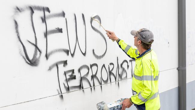 Workers paint over the anti-Semitic graffiti on Mount Sinai College in Maroubra. Picture Thomas Lisson