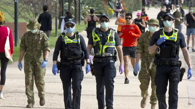 Police officers and army personnel patrol The Tan on Sunday. Picture: NCA NewsWire/David Geraghty