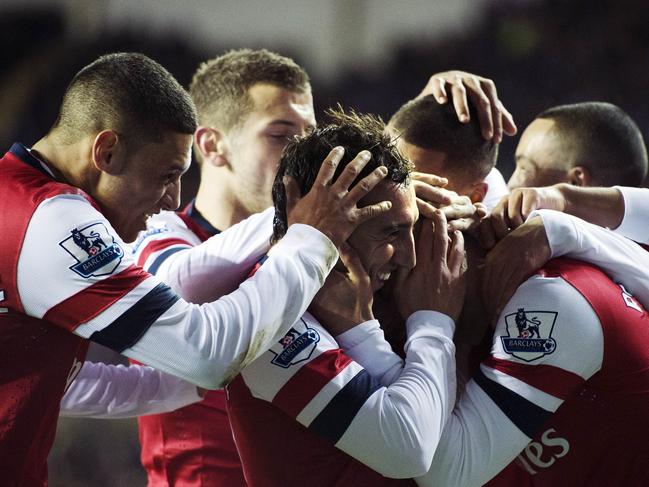 Arsenal players hug teammate Spanish midfielder Santi Cazorla (C) after scoring his hat-trick against Reading during the English Premier League football match between Reading and Arsenal at Madejski Stadium in Reading on December 17, 2012. Arsenal won the match 5-2. AFP PHOTO / ADRIAN DENNISRESTRICTED TO EDITORIAL USE. No use with unauthorized audio, video, data, fixture lists, club/league logos or ?live? services. Online in-match use limited to 45 images, no video emulation. No use in betting, games or single club/league/player publications.