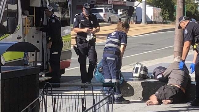 A homeless man is helped by police and paramedics.