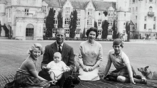 Baby Prince Andrew perches on Prince Philip's lap during a picnic on the grounds of Balmoral Castle. Also pictured are Queen Elizabeth, Prince Charles, and Princess Anne.